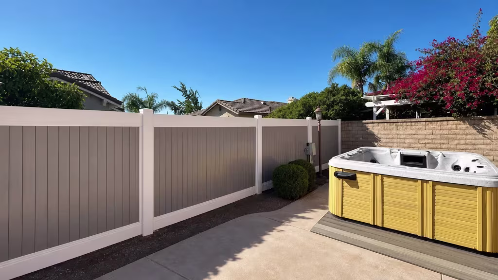 Two-tone Tan vinyl privacy fence spanning three panels that end at a masonry boundary post