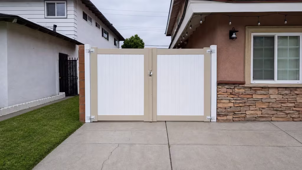 A masonry column and stone-veneer pier flank this two-tone Beige vinyl driveway gate
