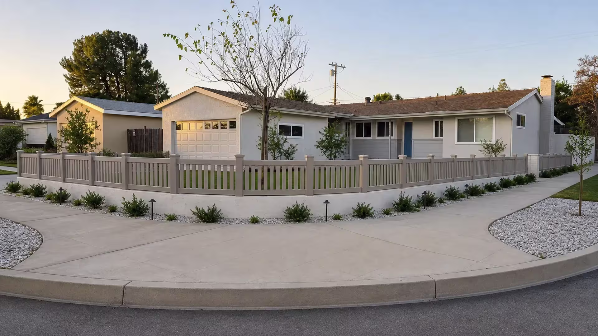 Ten bays of Clay vinyl pickets, closed at the top, ride this fence along a low masonry wall past a blue front door