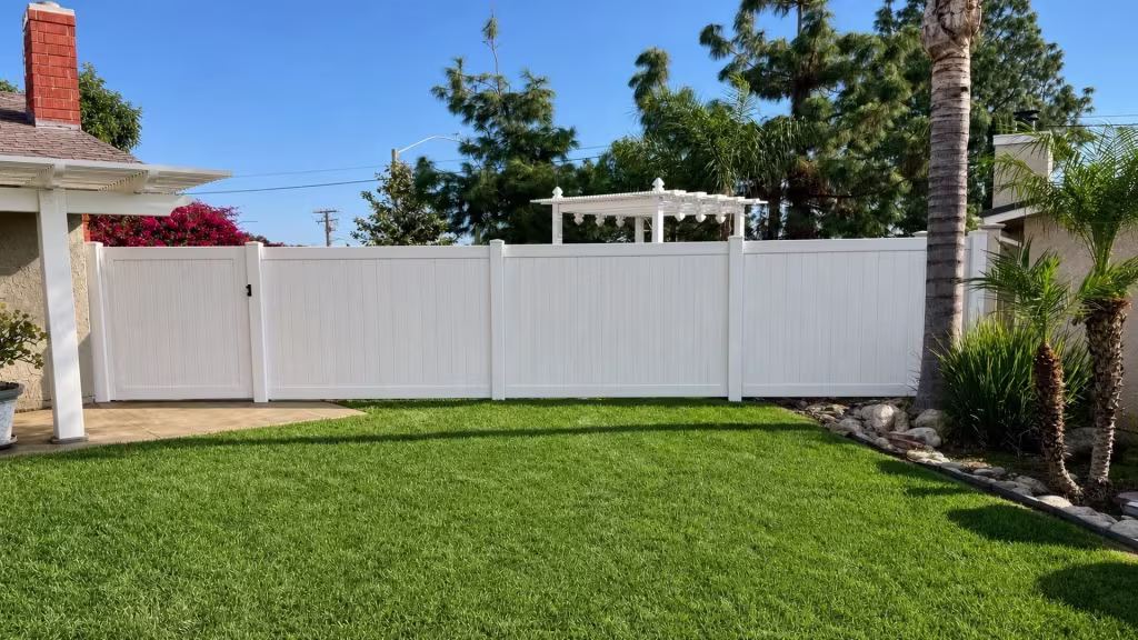 Weathered Aspen vinyl privacy gate and fence spanning a backyard beneath a white pergola and patio cover