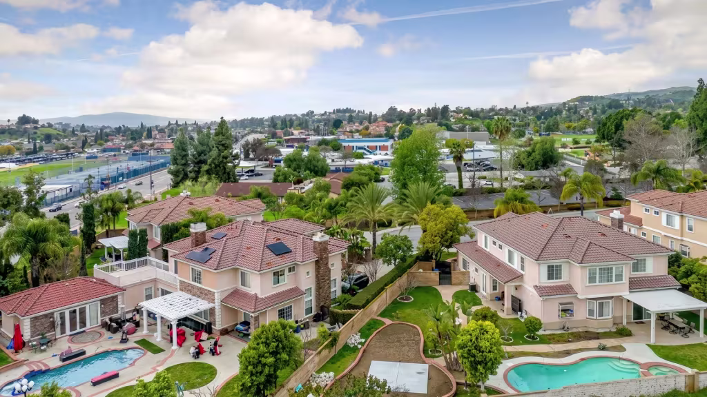 Hillside homes spread across green terrain in Walnut, captured in a high aerial oblique view