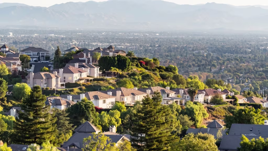 Hillside homes in Woodland Hills overlook the city basin and mountains beyond, from an elevated oblique view