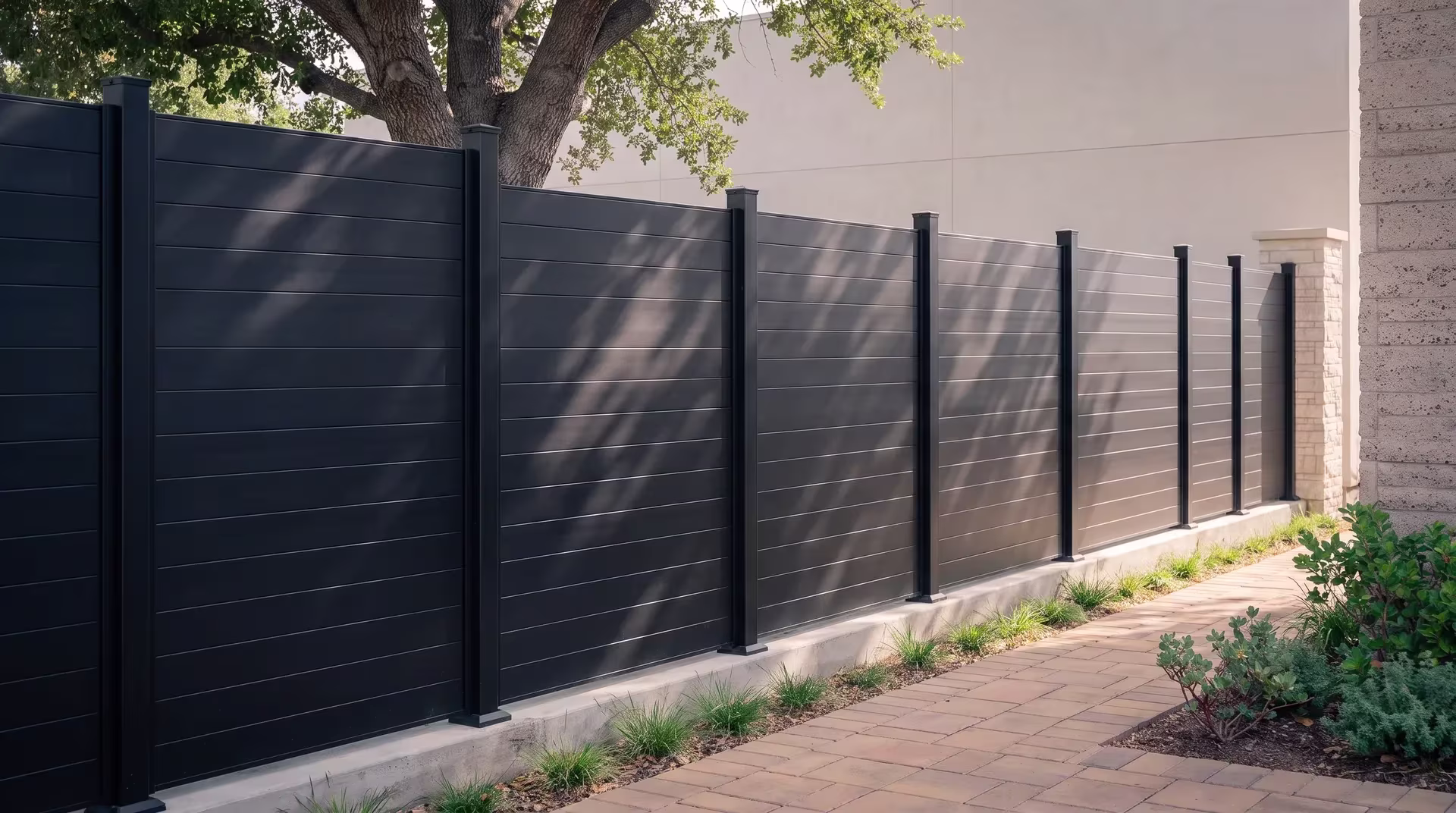 Manzanita and planted swales surround this Black aluminum privacy fence standing next to a bistro's smooth plaster wall
