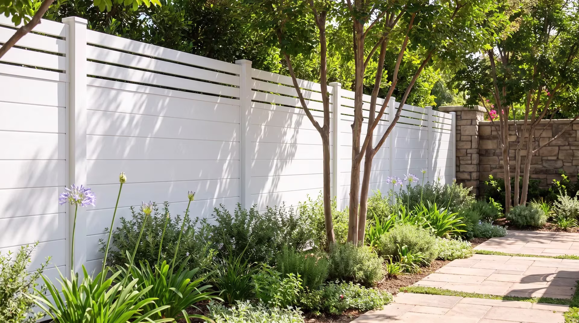 Multi-trunk crepe myrtle shades this White aluminum privacy fence enclosing a farm-to-table restaurant's dining court