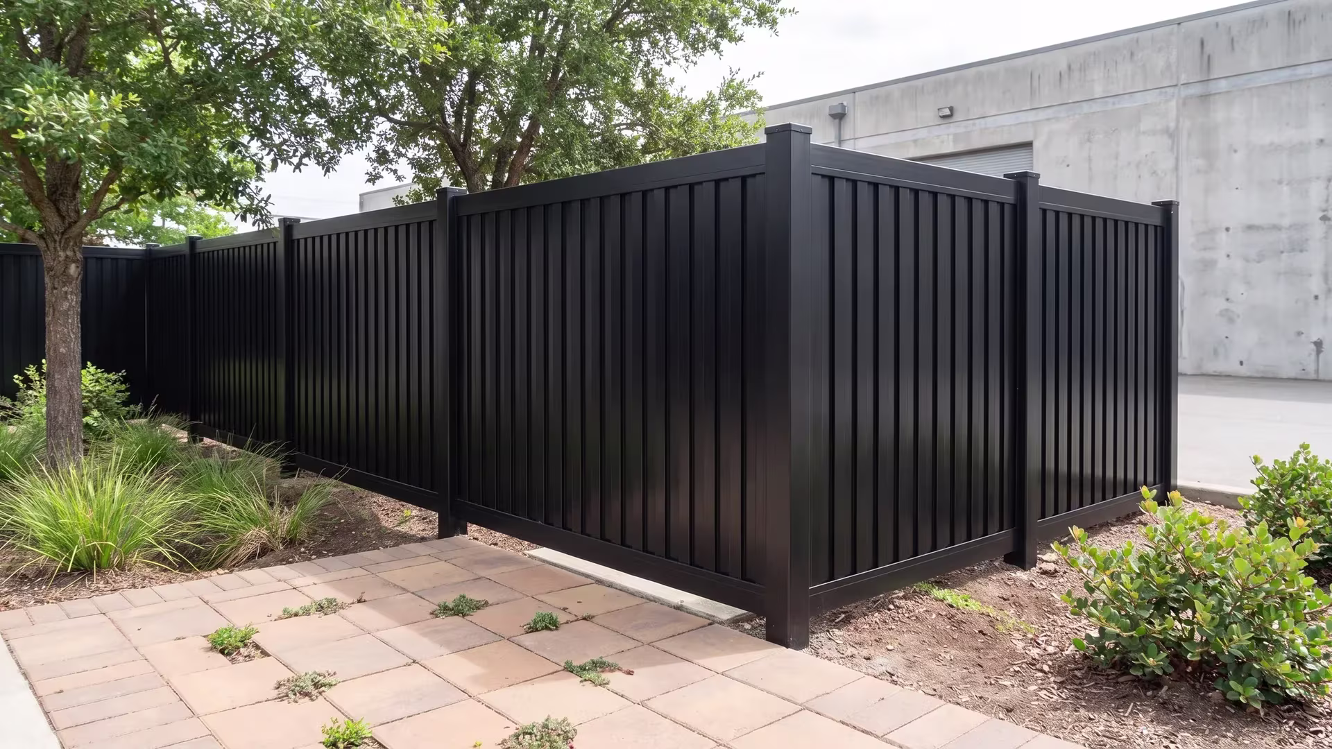 Aluminum vertical privacy shadowbox fence turns an L-shaped corner post in a design studio courtyard, done in Black