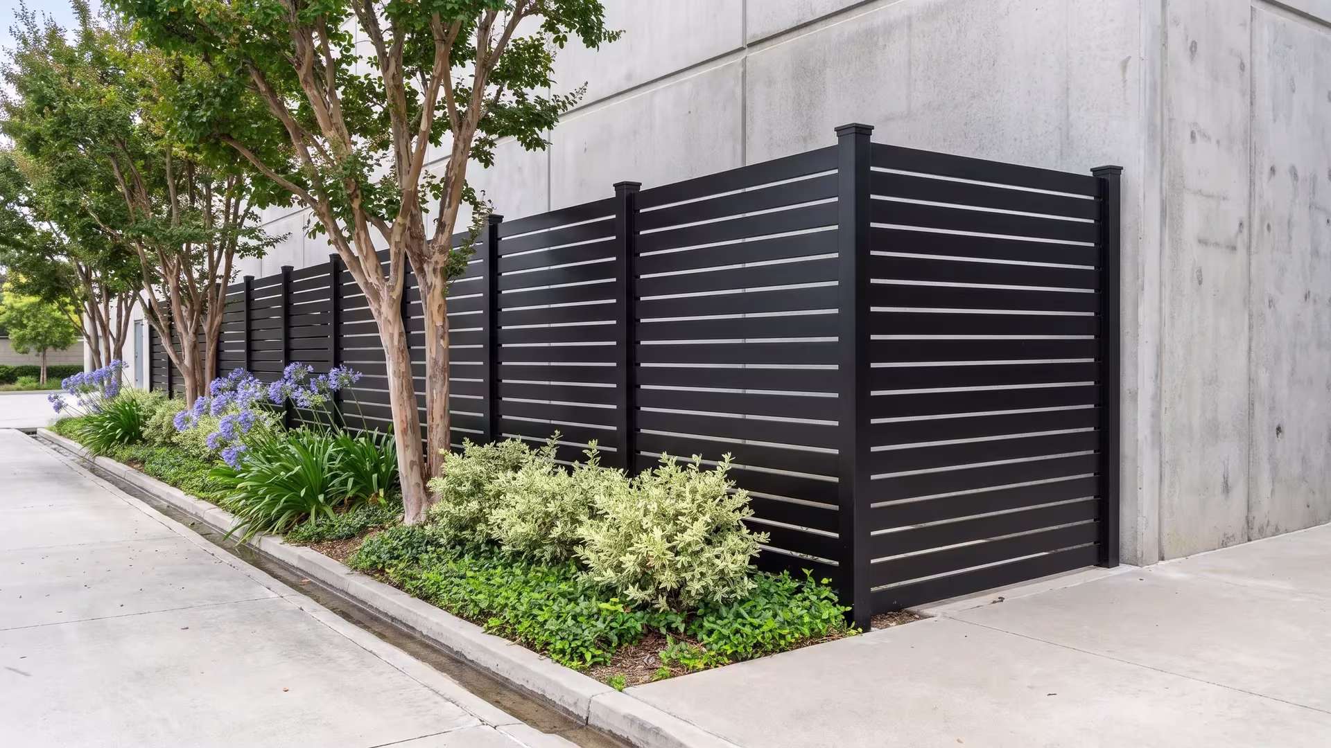 Black aluminum semi privacy fence enclosing a data center yard beside a concrete technical building