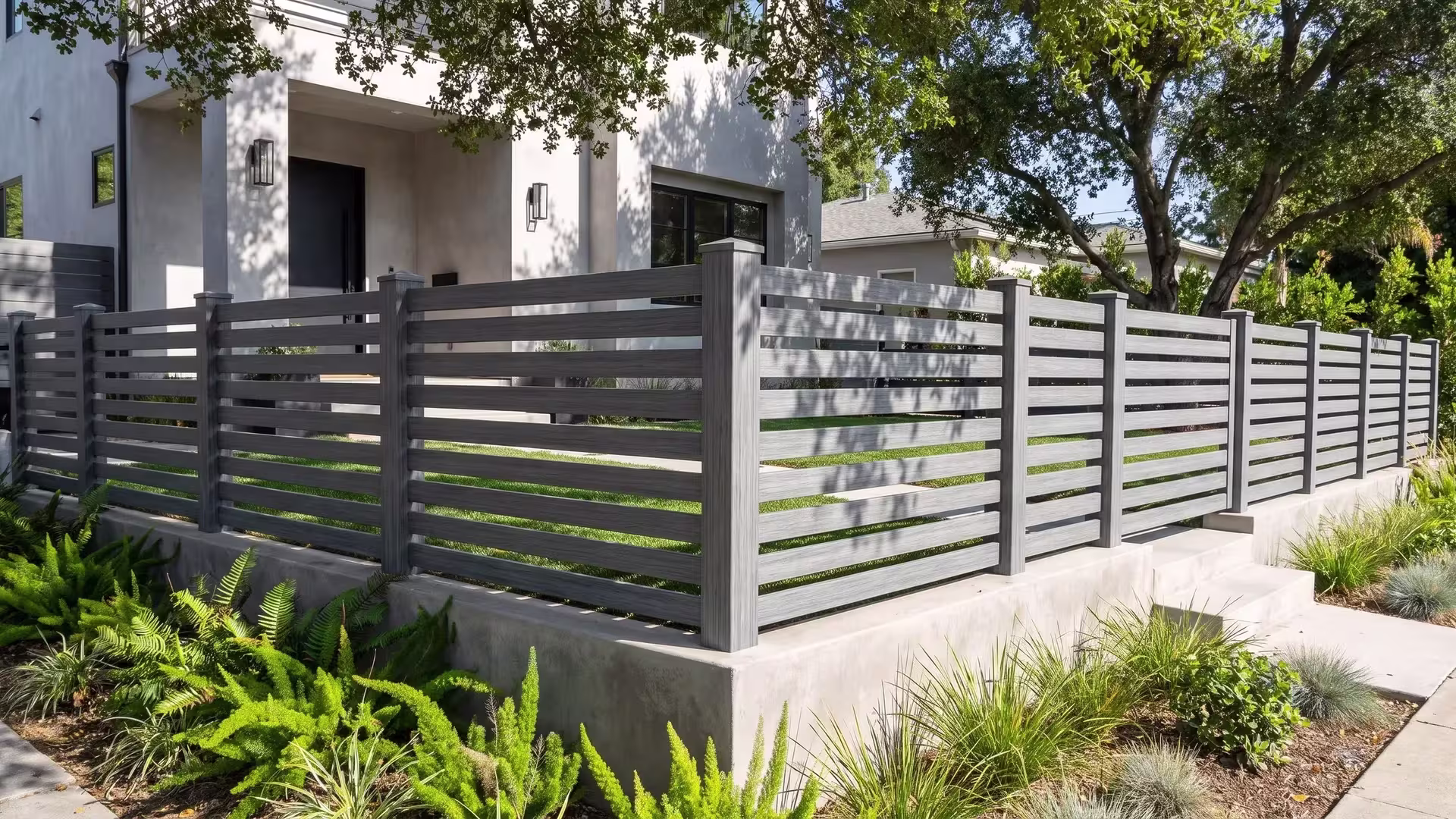 Arctic Blend vinyl horizontal picket fence lining a narrow lawn strip under coast live oak shade