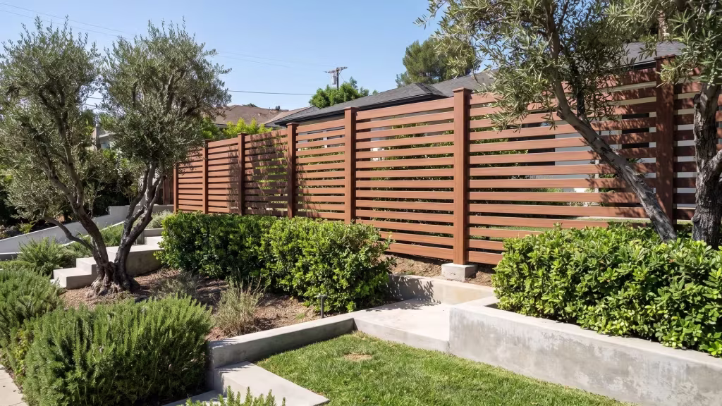 Brazilian Blend vinyl horizontal picket fence climbing past mature olive trees on a hillside lot