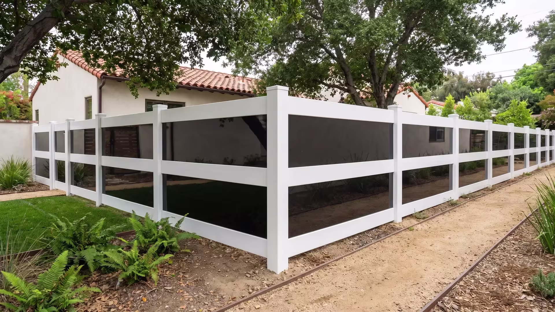 Compact urban yard framed by a White vinyl privacy fence with acrylic beneath coast live oak shade and ferns