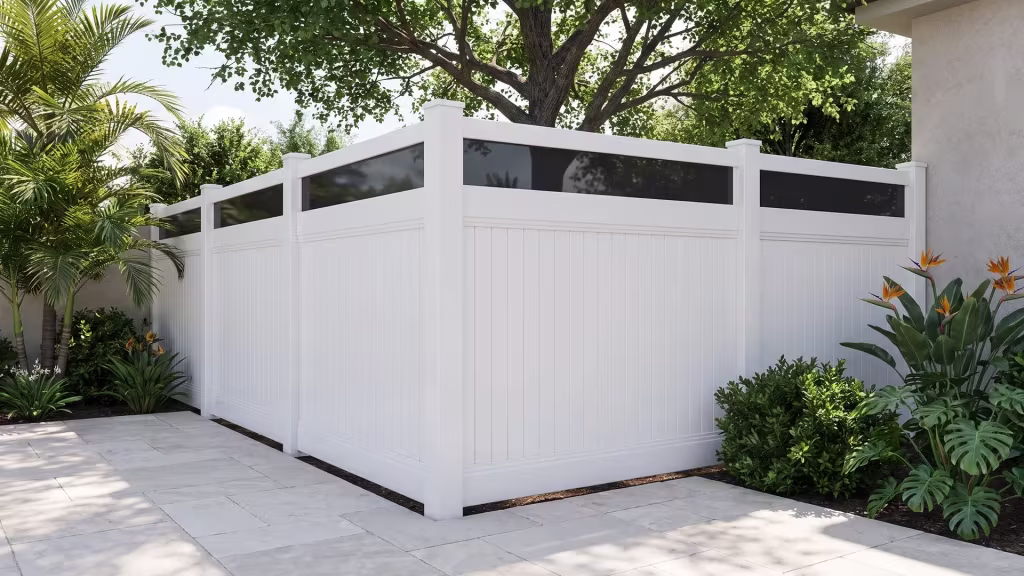 White vinyl vertical privacy fencing topped with acrylic panels shades a stucco backyard beneath a mature tree canopy
