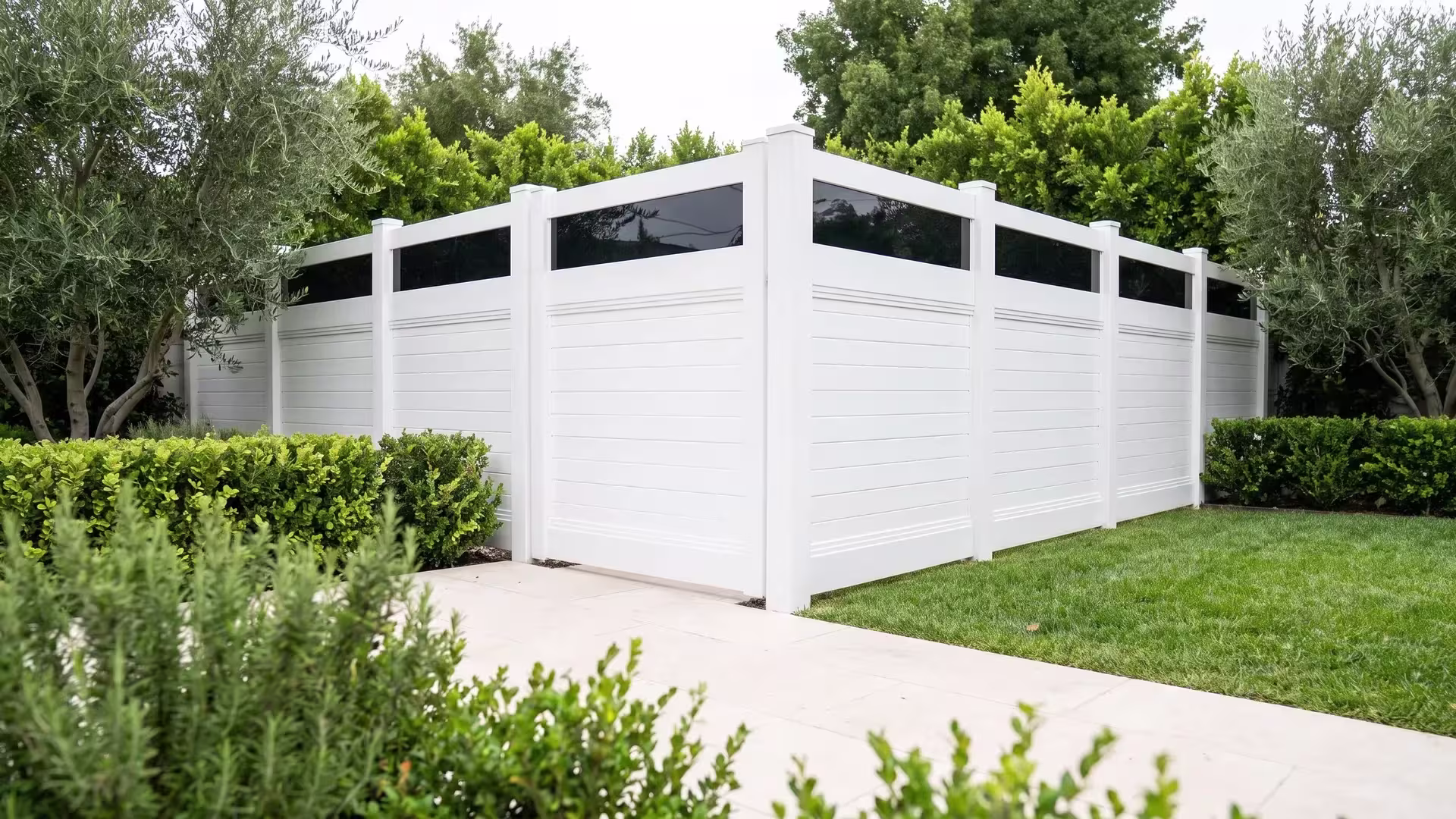 Horizontal White vinyl privacy fence, infill finished with an acrylic top rail, screening a duplex lawn from a stone patio