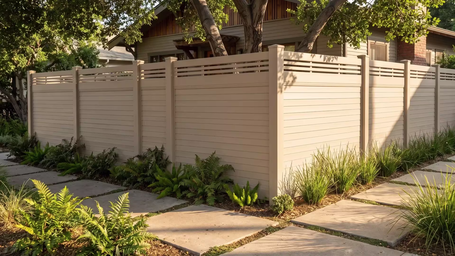 Tan vinyl horizontal-board privacy fence carries a horizontal picket top rail where the run turns at a corner lot