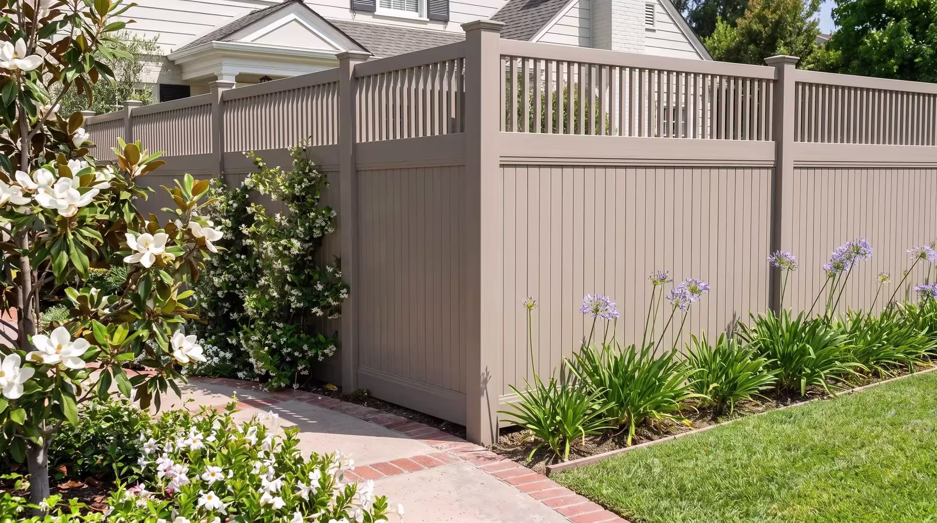 Clay vinyl fence turns a corner past a brick garden path, pickets crowning its vertical privacy boards