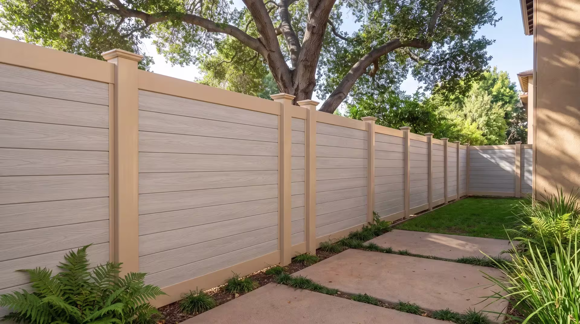 Concrete pavers and a coast live oak border this horizontal vinyl fence pairing Coastal Cedar boards with a Tan frame