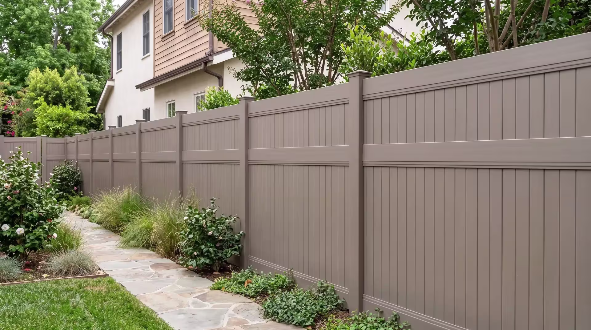 Clay vinyl vertical privacy fence tracing a flagstone path through a compact urban backyard