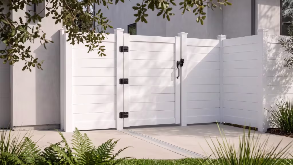White single side aluminum gate sealed by full privacy infill on an urban driveway beside a smooth stucco facade