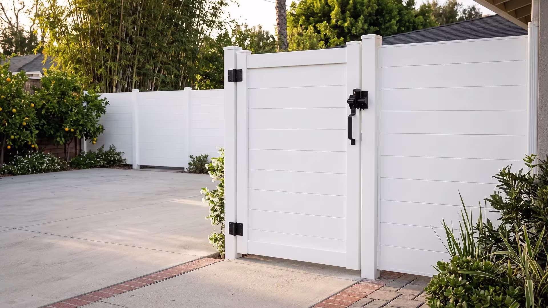 White aluminum gate breaks a long fence line at a ranch motor court, full privacy infill filling the single side opening