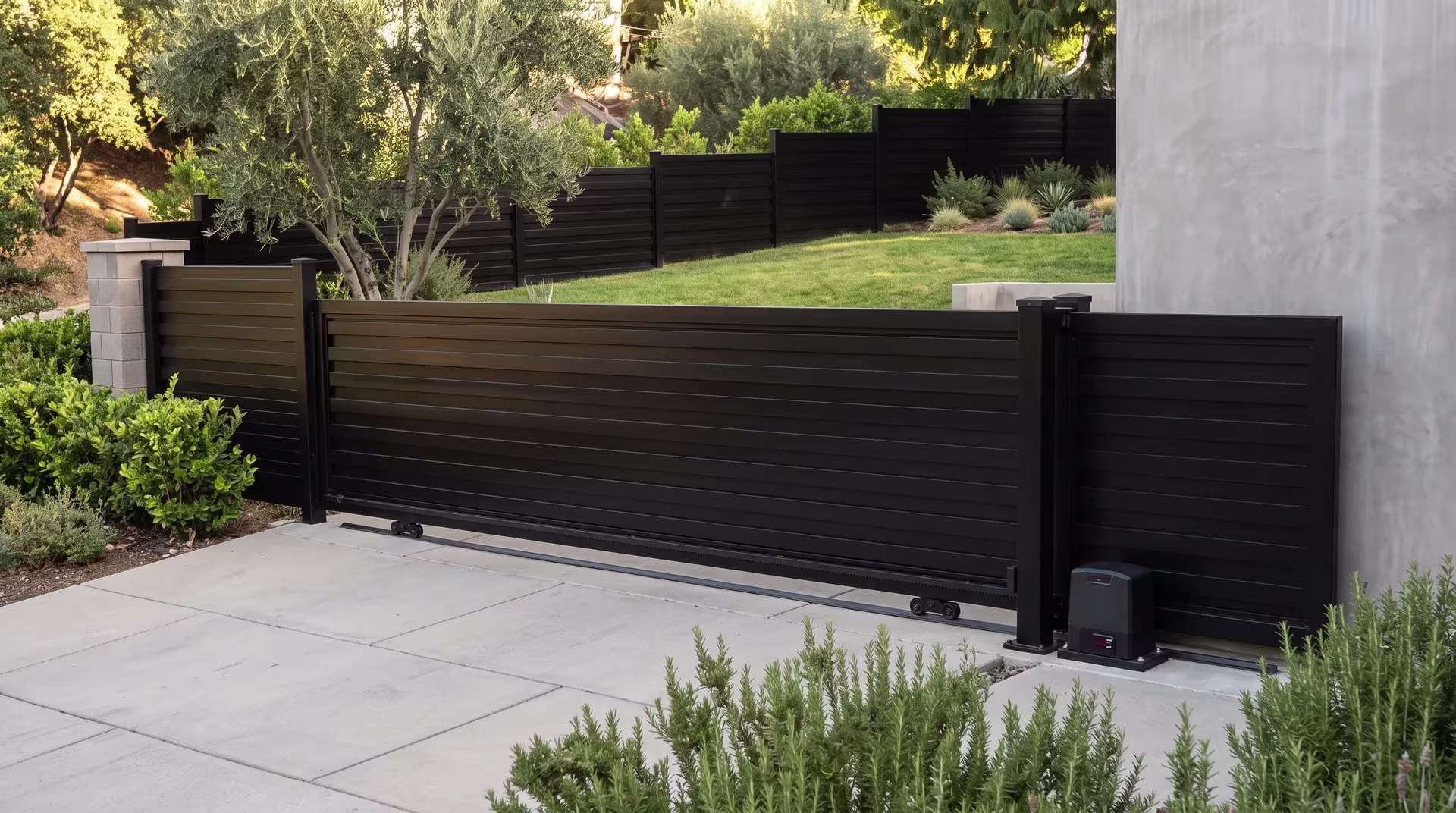 Black horizontal privacy shadowbox aluminum sliding gate closing a level parking terrace on a hillside property