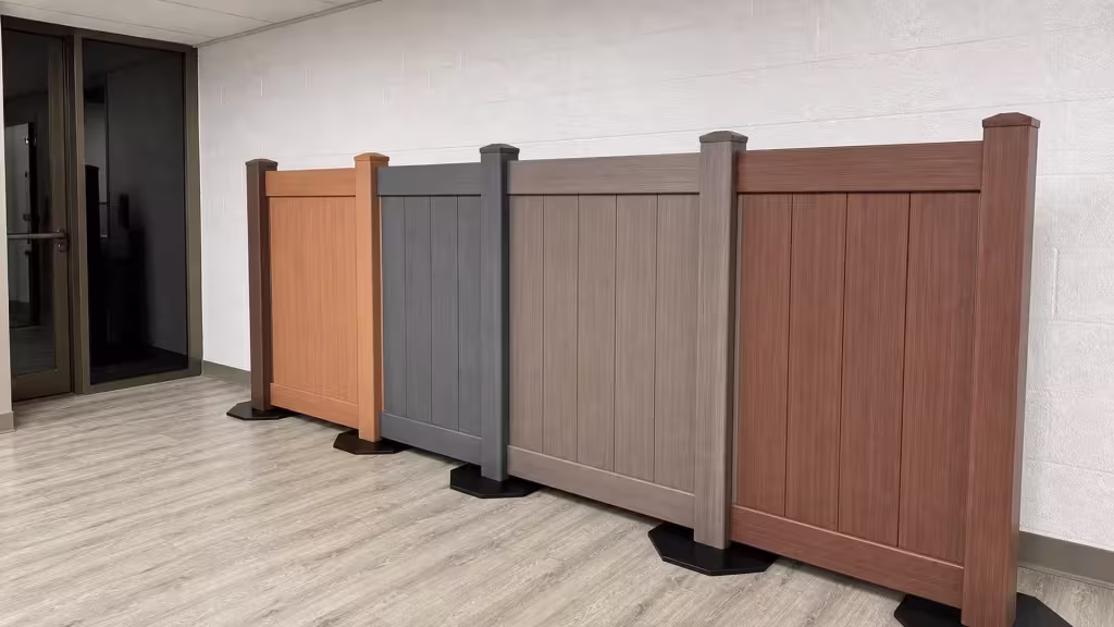 Four full-height vinyl privacy panels in the showroom, left to right: Sierra Blend, Arctic Blend, Weathered Blend and Brazilian Blend wood grains